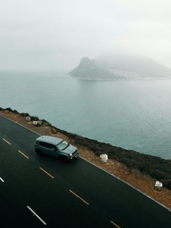 A cable car going up Table Mountain with Cape Town and the ocean below.
