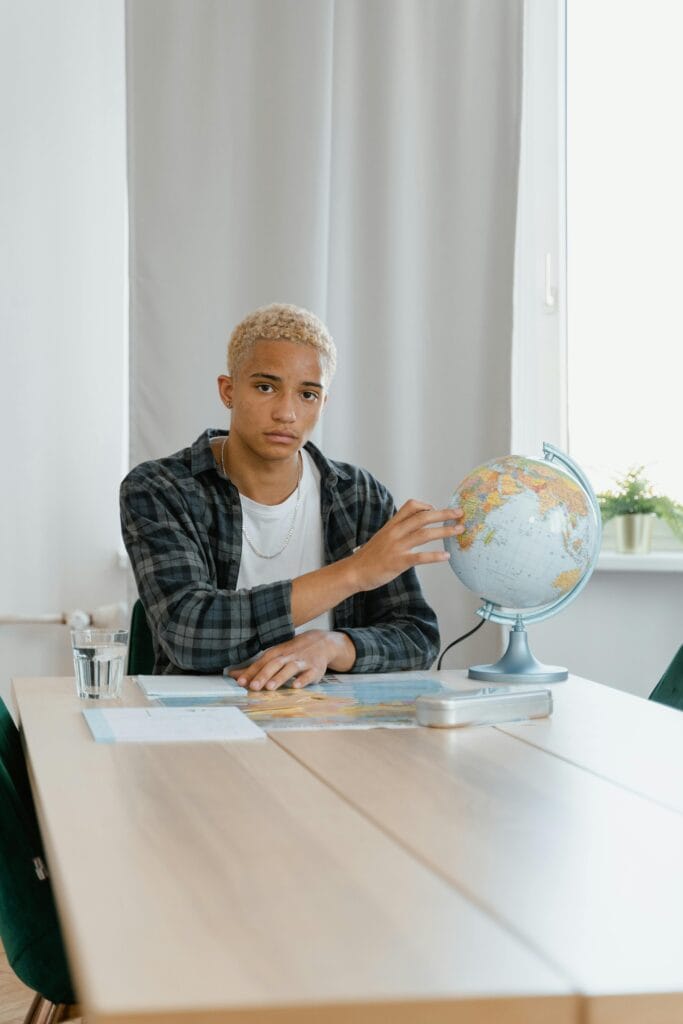 A person holding a lightbulb labelled "Learn English Faster" by books,