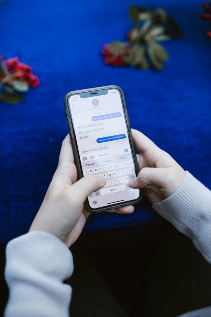 A smartphone screen showing a friendly English chatbot conversation, with messages like “Hi! Let’s talk about your weekend.”